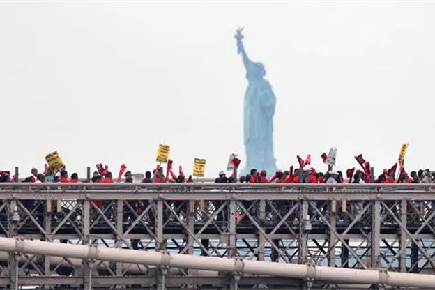 Protesters on the Brooklyn Bridge, with the Statue of Liberty in the background